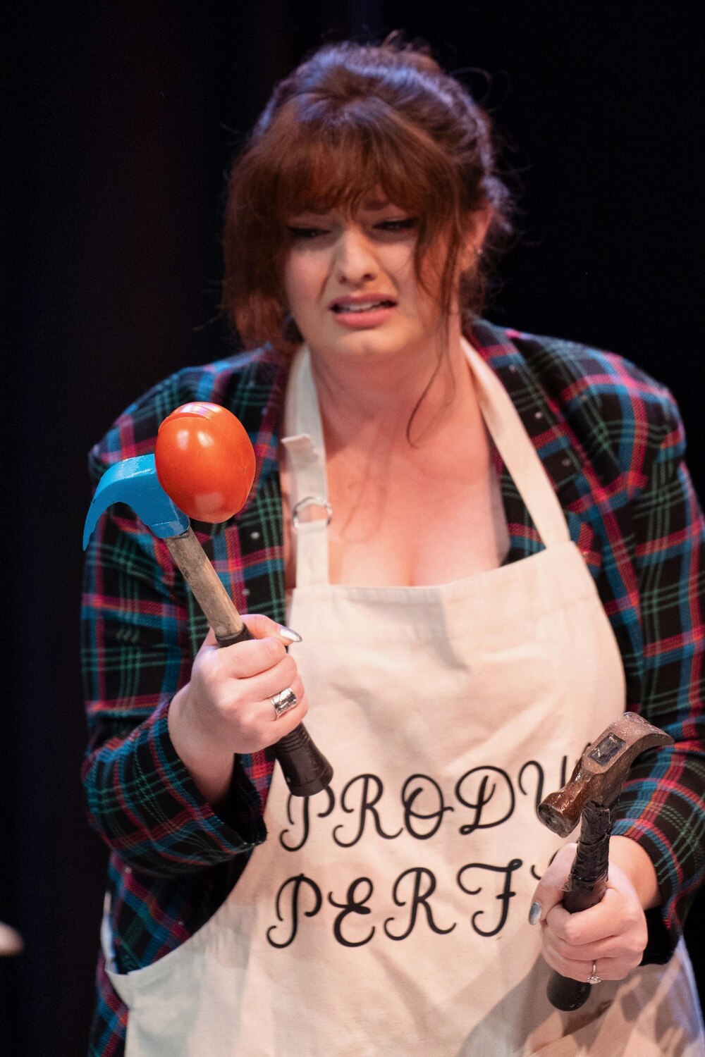 Paige holding two suspicious hammers onstage